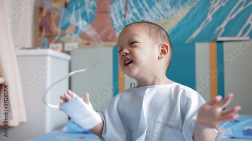 Young Boy Happily Enjoying and Clapping and jumping Up and Down While in Qurintine on hopspital bed during Global Pandemic