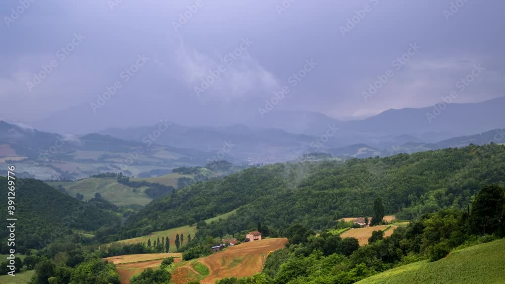 Rain clouds creation appearance uprise timelapse over rural field hills in Italy, nature outdoor landscape panorama view. Green grass, rainy natural scenery. High quality 4k footage Rain clouds creation appearance uprise timelapse over rural field hills in Italy, nature outdoor landscape panorama view. Green grass, rainy natural scenery. High quality 4k footage