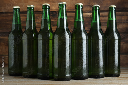Green bottles of beer on wooden table