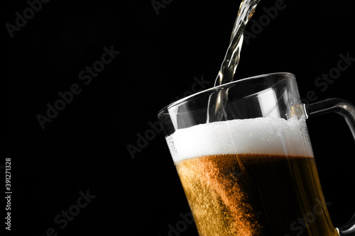 Wallpaper Mural Pouring cold tasty beer into glass mug on black background, closeup. Space for text Torontodigital.ca