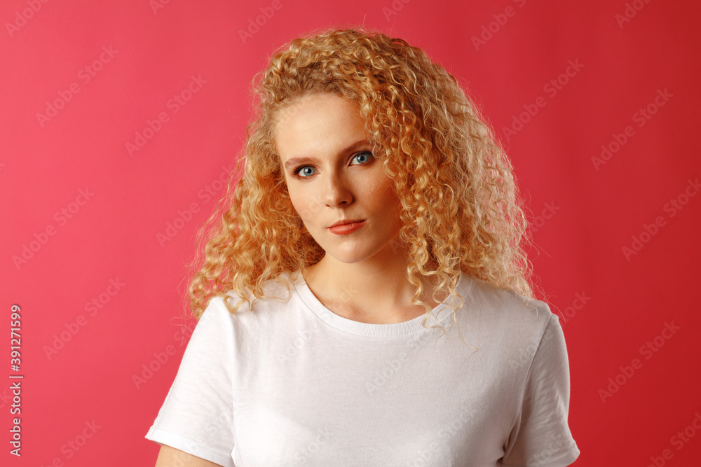 Fototapeta premium Gorgeous beautiful young woman with curly hair posing at camera