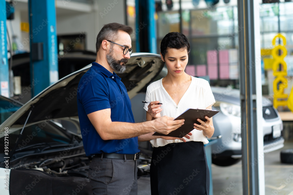 Car insurance concept. Insurance Agent examine Damaged Car with woman customer write information on Report Claim Form. Car insurance concept. Insurance Agent examine Damaged Car with woman customer write information on Report Claim Form.