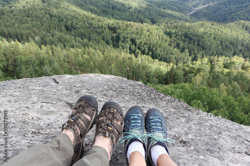 Male and female legs in trekking shoes on the top of mountain , Altai Mountains, Belokurikha City, Russia