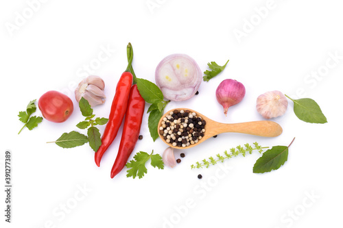 Pepper in a wooden spoon and red chili basil, garlic and spices Isolated on white background - top view
