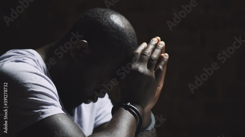 African suspect man with handcuffs in interrogation room after being caught