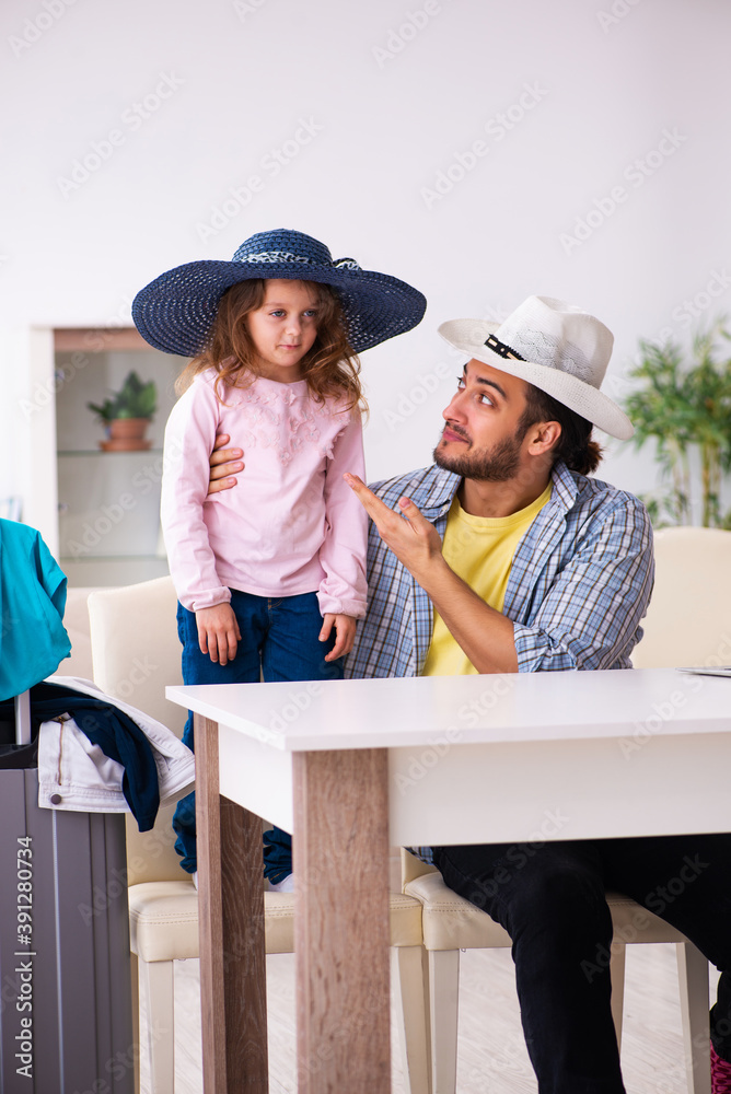 Young man and his small daughter preparing for the trip