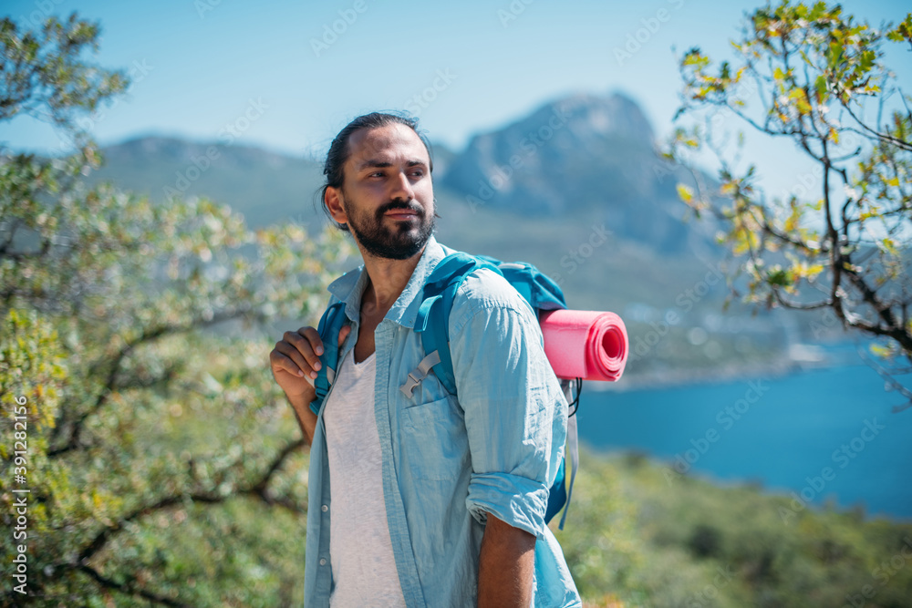 Obraz premium Male tourist in a mountain grove overlooking the sea