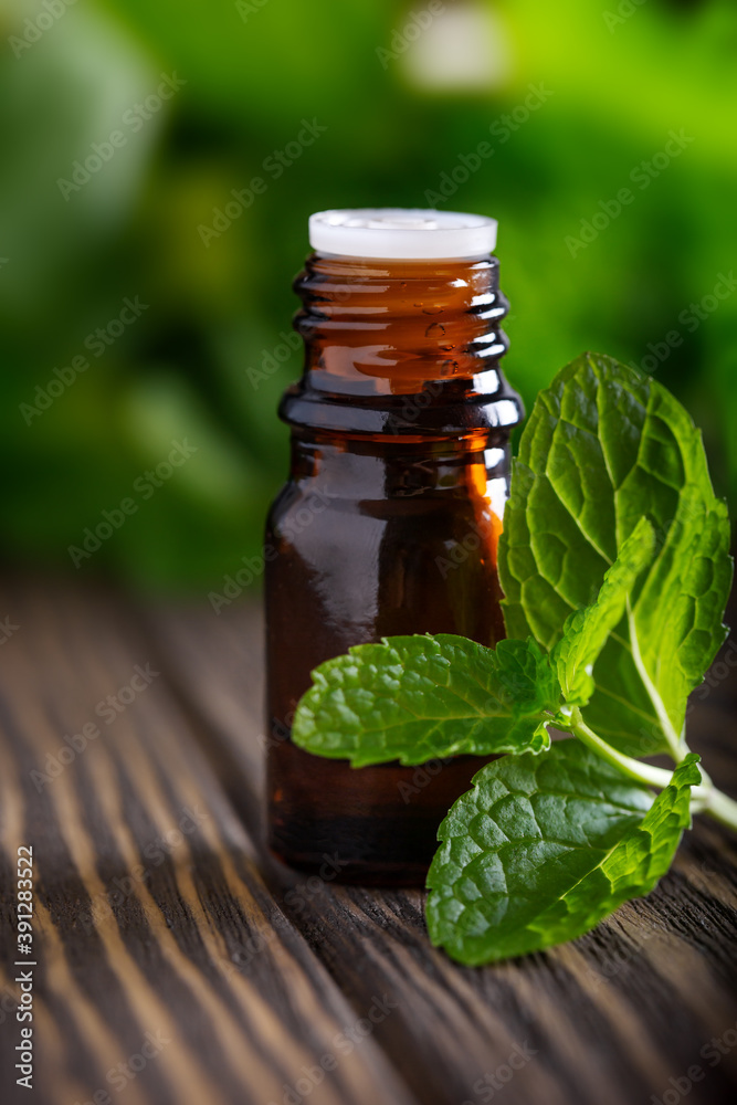 Blank amber bottle with essential oil Peppermint with mint leaves Blank amber bottle with essential oil Peppermint with mint leaves