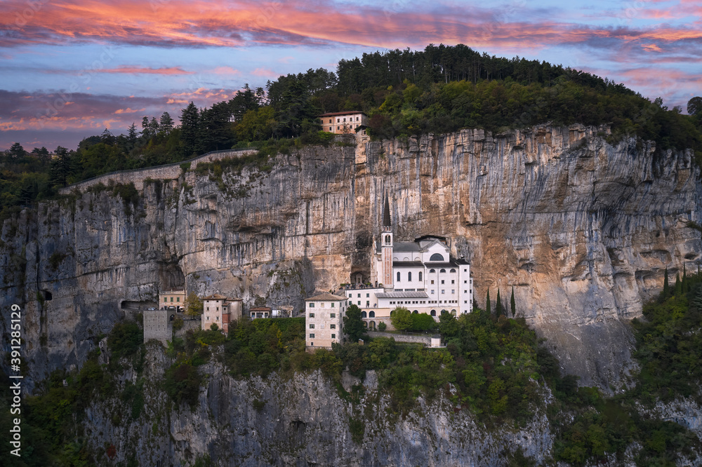 The unique Sanctuary Madonna della Corona church was built in the rock. Aerial view of the church on the sheer cliff. Italian church in the Alps. The sanctuary is high in the mountains of Italy.