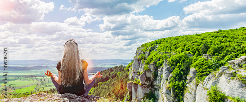 Grauhaarige Frau, die eine Meditation in der natürlichen Landschaft macht