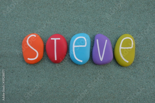 Steve, masculine given name composed with multicolored stone letters over green sand photo