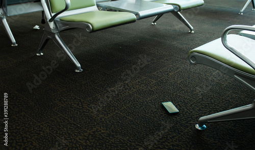 Smartphones found on carpet under the seat of a international airport, Mobile phone dropped on the ground and forgotten, Concept of mobile communication in travel and lost gadgets in the airport, 