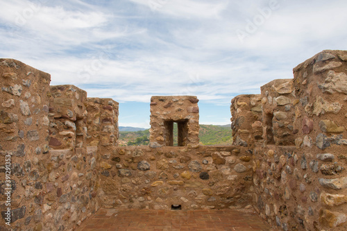 Battlements of a castle tower and the mountains in the background