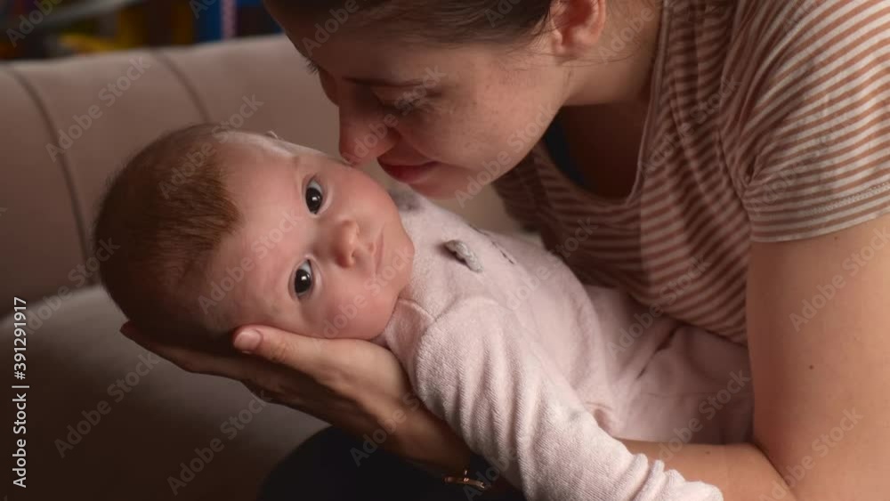 Close up photo of a caucasian mother playing with her little daughter while holding her in hands and smile Close up photo of a caucasian mother playing with her little daughter while holding her in hands and smile