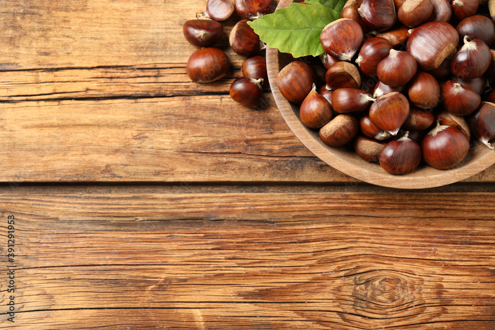 Fresh sweet edible chestnuts on wooden table, flat lay. Space for text Fresh sweet edible chestnuts on wooden table, flat lay. Space for text