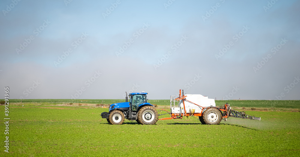 Wide angle image of a crop spray machine spraying chemicals on wheat crop on a farm in south africa Wide angle image of a crop spray machine spraying chemicals on wheat crop on a farm in south africa