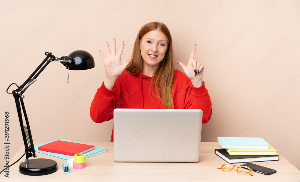Young student woman in a workplace with a laptop counting seven with fingers Young student woman in a workplace with a laptop counting seven with fingers