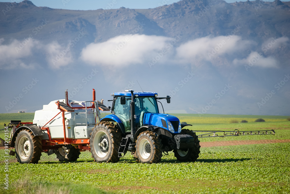 Wide angle image of a crop spray machine spraying chemicals on wheat crop on a farm in south africa Wide angle image of a crop spray machine spraying chemicals on wheat crop on a farm in south africa