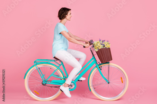Fototapeta Naklejka Na Ścianę i Meble -  Profile full length photo of cute lovely woman riding vintage bicycle wear blue t-shirt white trousers shoes isolated pink background