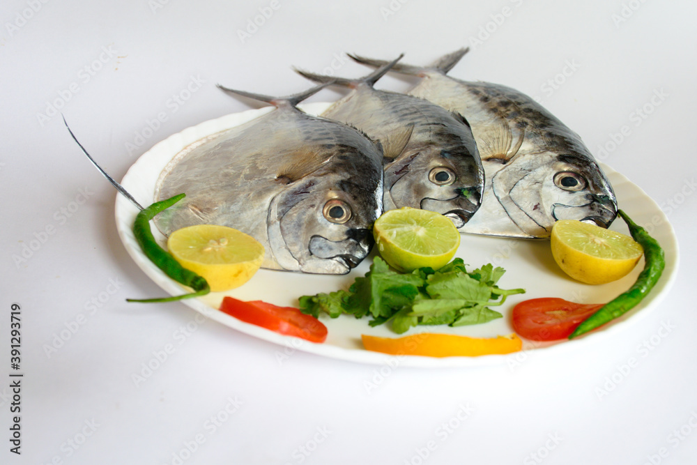 Fresh Razor moonfish/Razor Trevally Fish, Decorated with herbs and lemon  slice on a white plate. Stock Photo