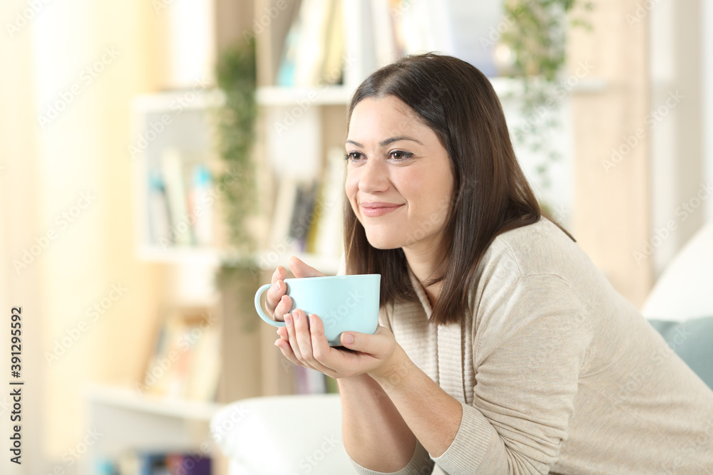 Satisfied woman thinking and drinking coffee at home Satisfied woman thinking and drinking coffee at home