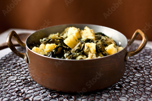 Potatoes and collard in pot photo