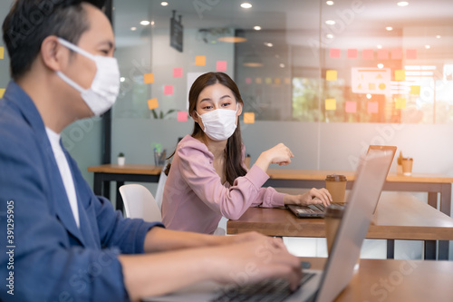 Asian workers in offices wear face masks to prevent the spread of COVID-19. Working in the new normal era and Social distance.