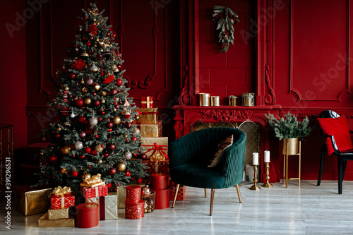 Beautiful festively decorated room with a Christmas tree. Cozy living room in red tones with a stylish classic decor.