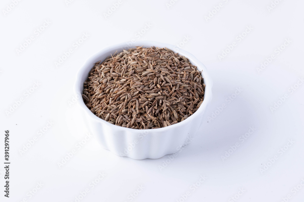 Cumin in a white ceramic cup on a white background Cumin in a white ceramic cup on a white background