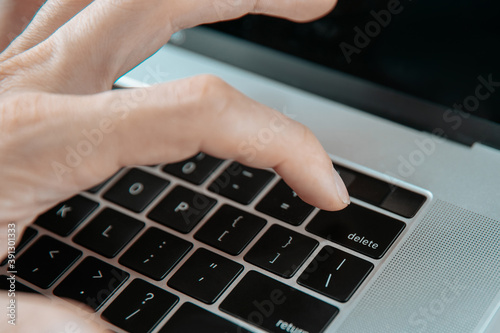 close up. man pressing the Delete key on his laptop.