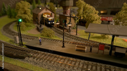 Model of retro railway station. Moniature railroad and people. photo