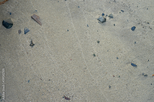 Sandy bottom of the reservoir close-up. Stones in the sand.