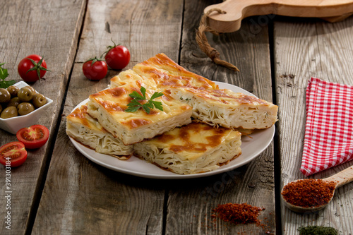 Water pastry on the plate. Composition of water pastry, tomato, hot pepper and olives on old wooden table.