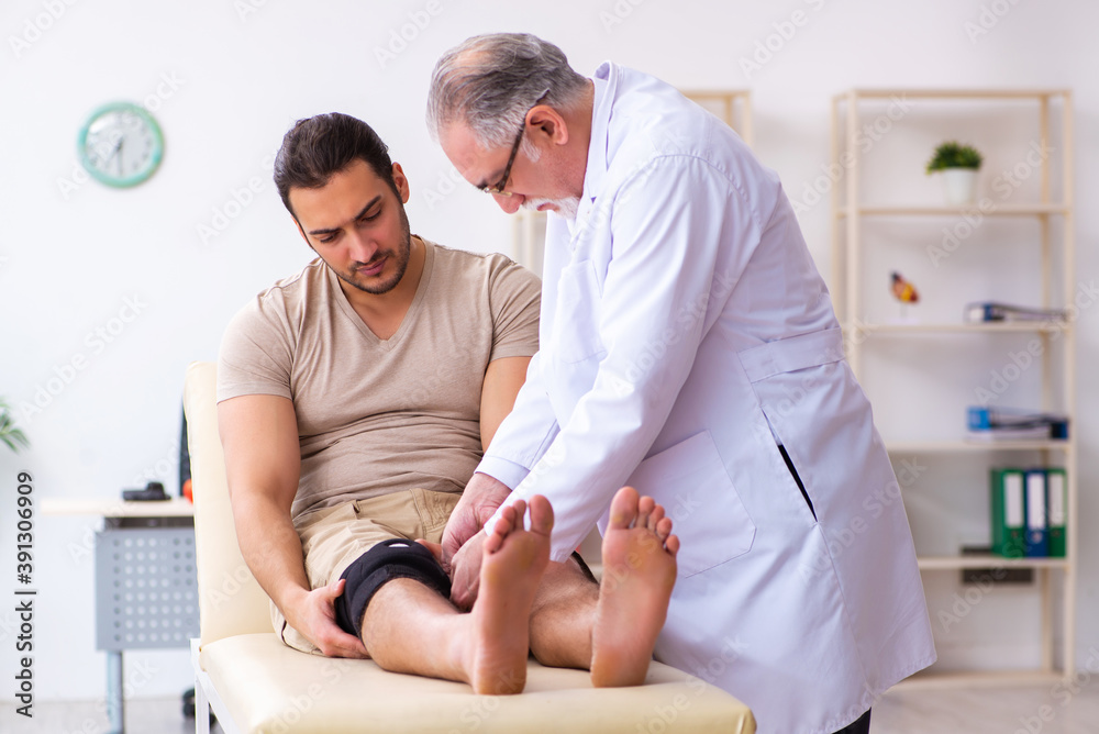 Obraz premium Experienced doctor traumatologist examining young male patient
