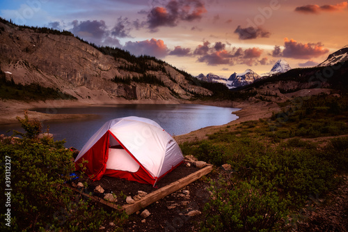 Camping Tent in the Iconic Mt Assiniboine Provincial Park near Banff, Alberta, Canada. Canadian Mountain Landscape in Background. Sunset Sky. Concept: Adventure, Hiking, Backpacking, Freedom photo