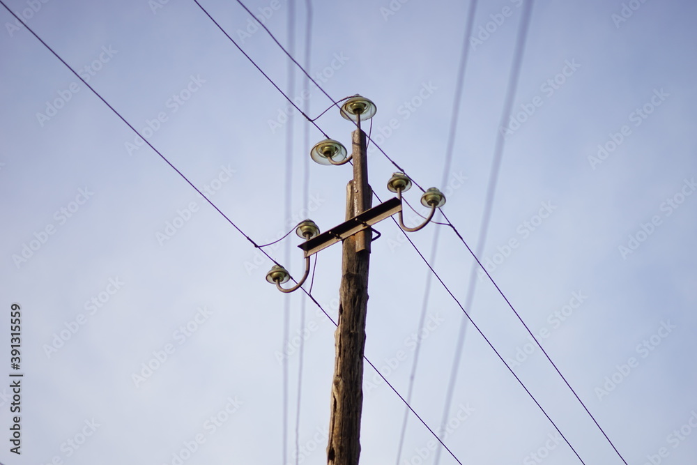old wooden pillar with wires on clear blue sky background. old wooden pillar with wires on clear blue sky background.
