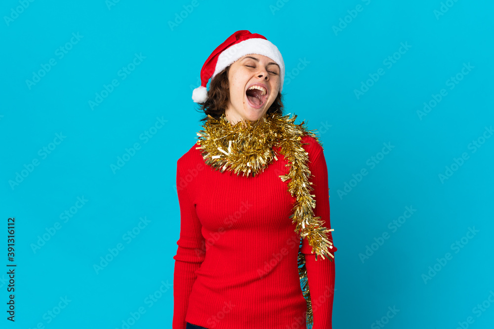 English girl with christmas hat isolated on blue background laughing English girl with christmas hat isolated on blue background laughing