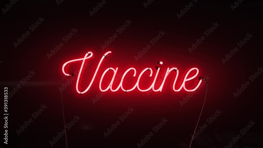 A bright red neon sign that says the word Vaccine on a dark black background A bright red neon sign that says the word Vaccine on a dark black background