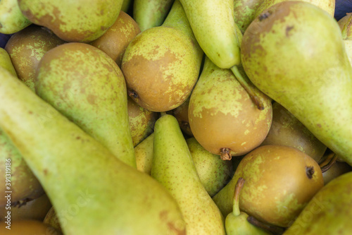 Fresh green pears in a box on the counter.