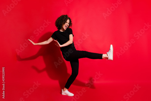 Photo portrait full body view of girl kicking raising leg dancing isolated on vivid red colored background