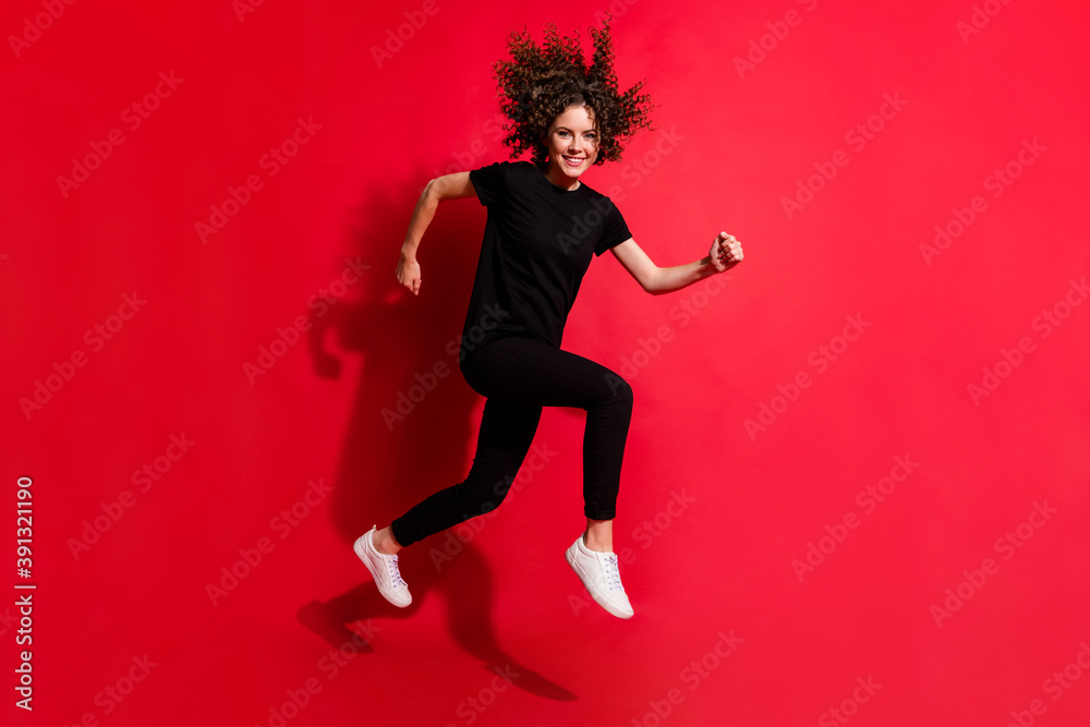 Photo portrait full body view of woman running jumping up isolated on vivid red colored background Photo portrait full body view of woman running jumping up isolated on vivid red colored background