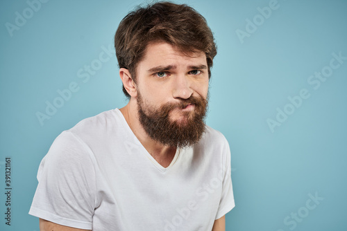 Man in white t-shirt emotions facial expression cropped view studio blue background lifestyle