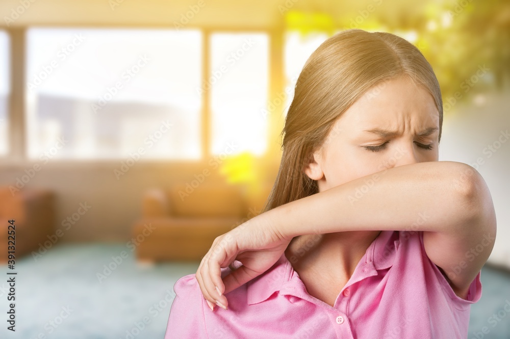 Young woman scratching her nose with elbow on background Young woman scratching her nose with elbow on background