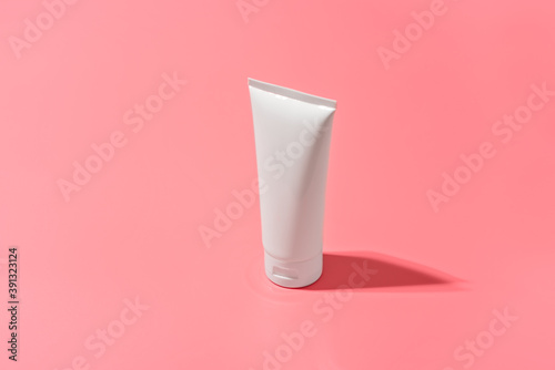 Blank white tube design on a pink background. Mockup