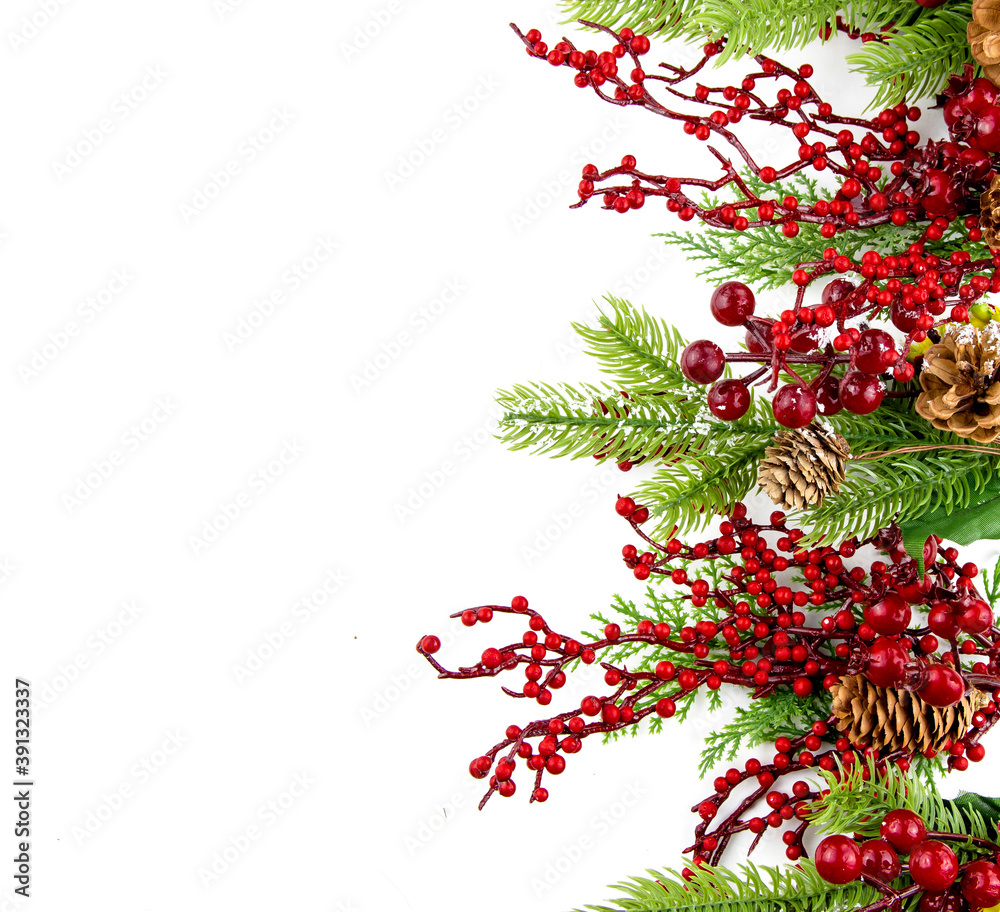 Christmas composition with copy space and decorative branches with cones and red berries.