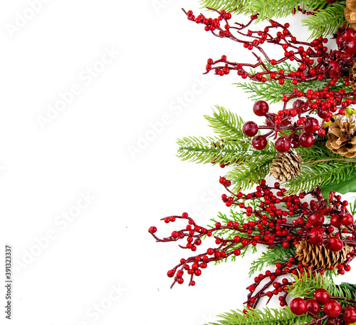 Christmas composition with copy space and decorative branches with cones and red berries.
