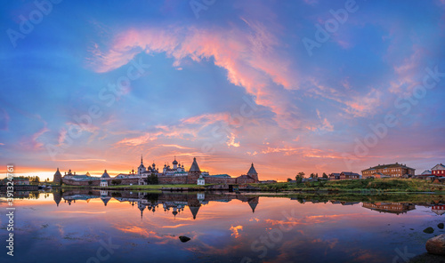 Solovetsky Monastery with a mirror image in the water under a beautiful dawn pink sky