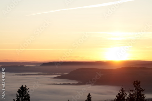 The fog is dense and like a lid on top of Oslo  Norway. Clear sky above the fog and it almost loos like clouds. Shot in golden hour and blue hour to get the best light. Shot from Holmenkollen. 