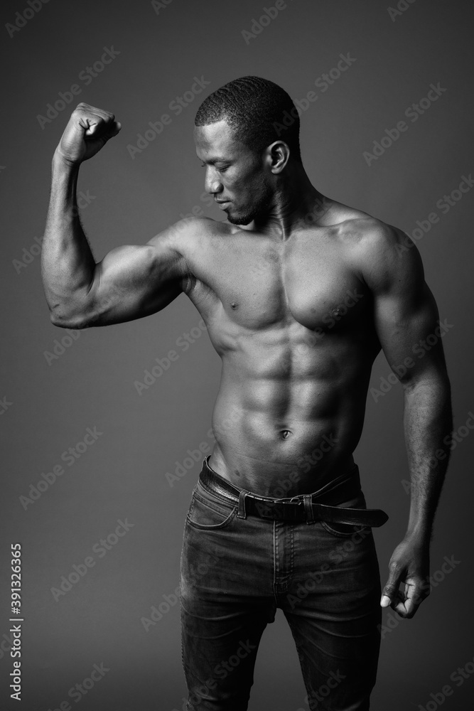 Handsome muscular African man shirtless against brown background