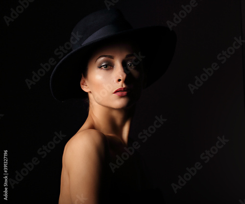 Beautiful makeup woman with elegant healthy neck, nude back and shoulder on black background in fashion hat with empty copy space. Closeup front view portrait. © nastia1983